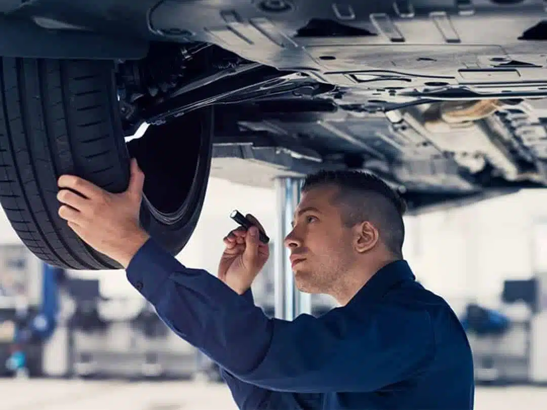 Servicetekniker inspekterar ett däck vid en bilservice