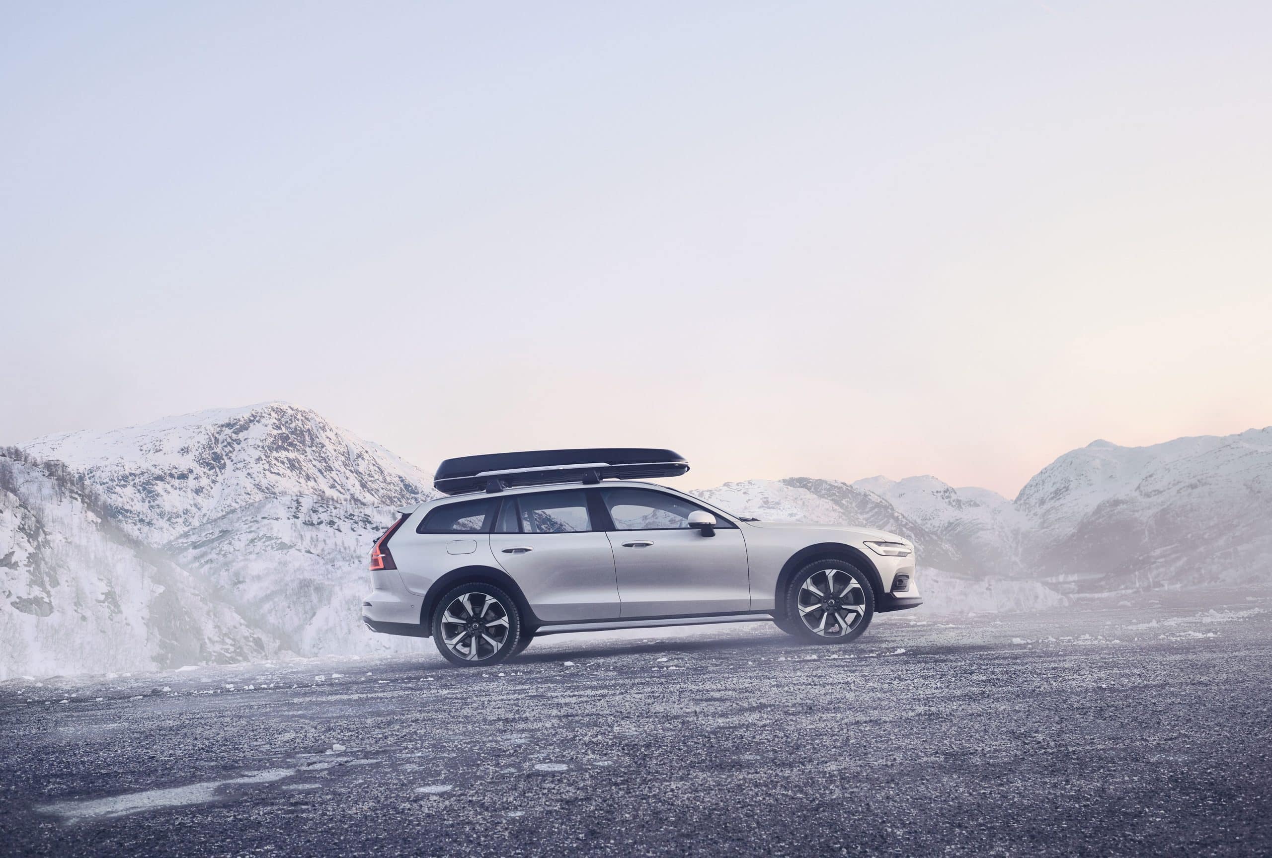 En bil, Volvo V60, åker i ett vinterlandskap i fjällen.