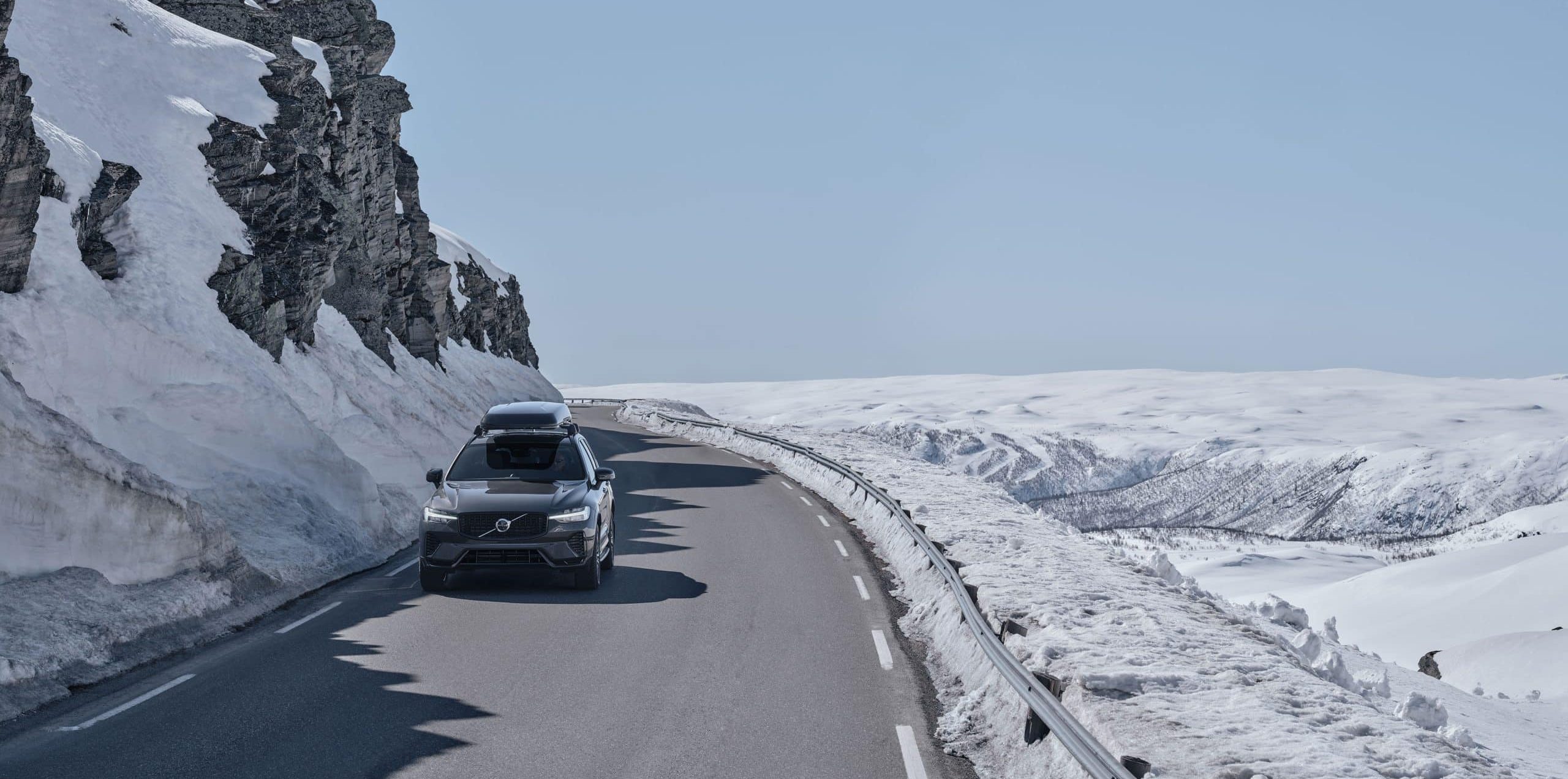 Volvo XC60 kör längs en vinterväg med snö.
