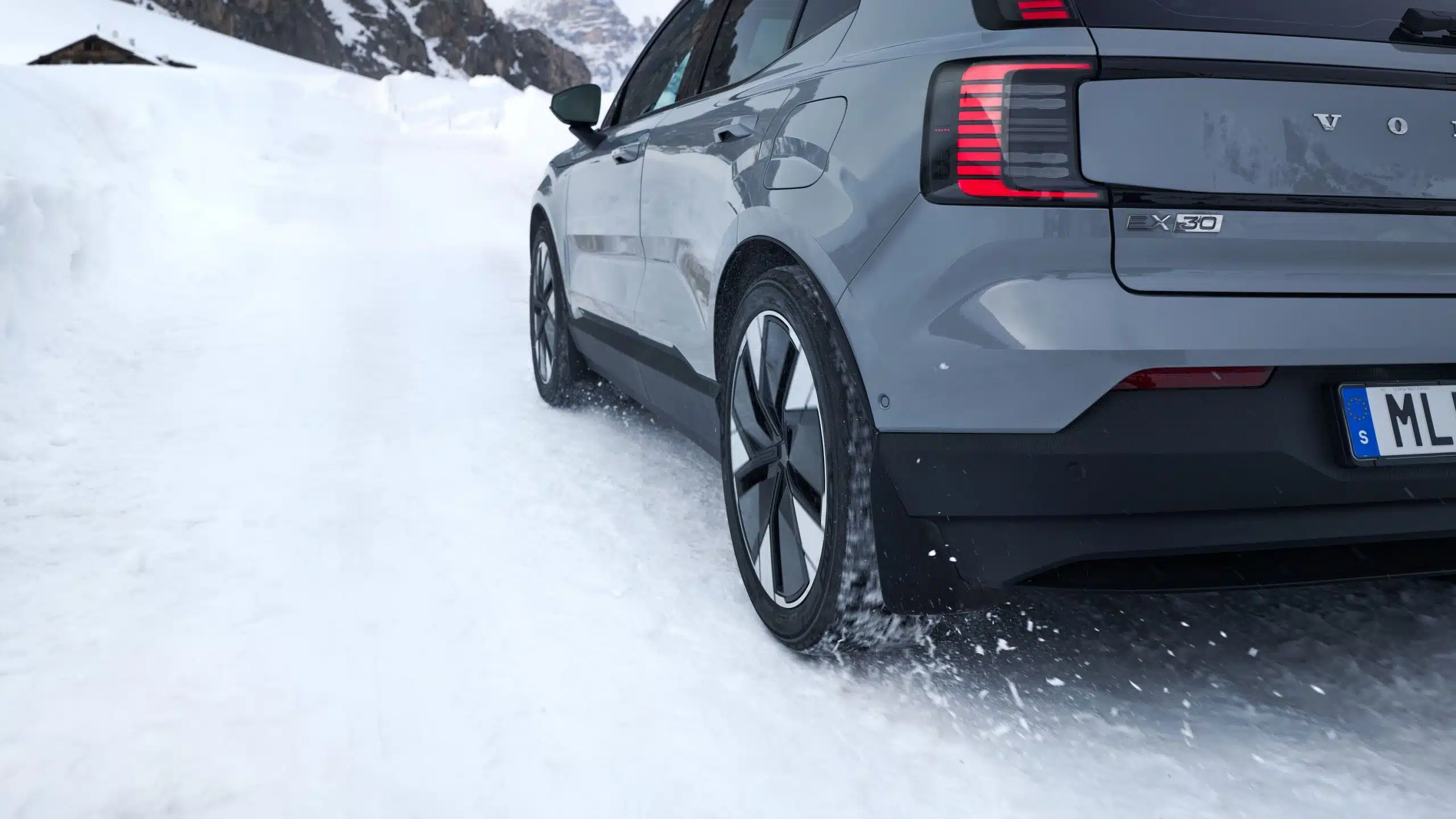 En grå bil kör på vinterväg med vinterdäck.